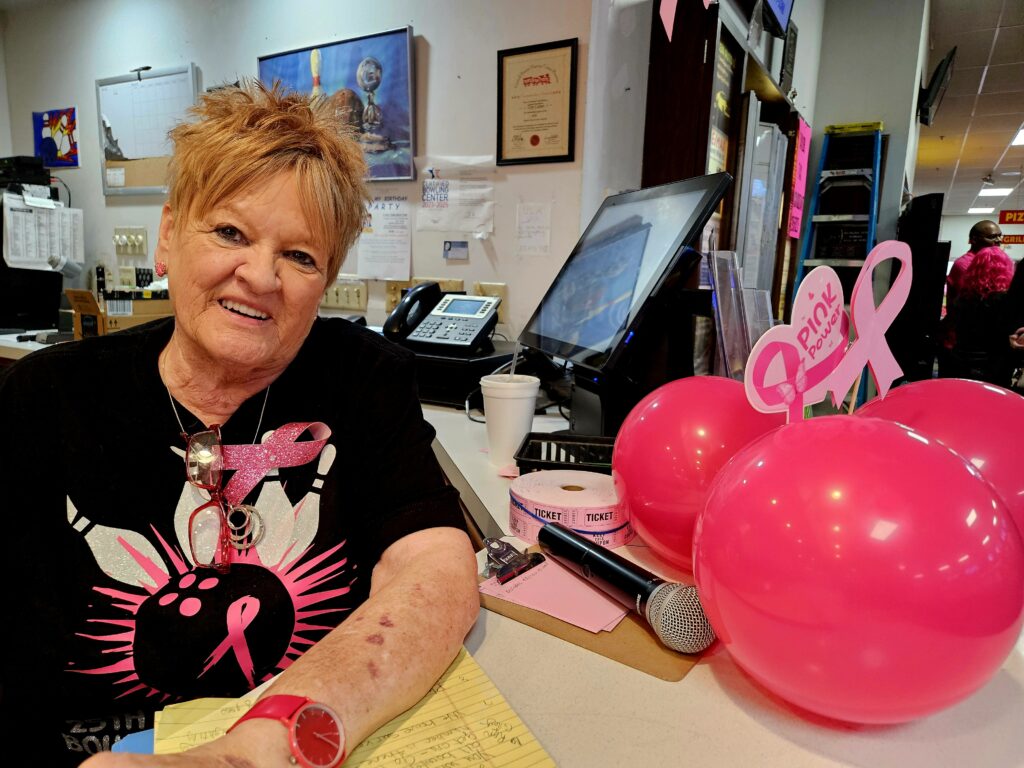 Cheryl Hale seated with pink balloons.