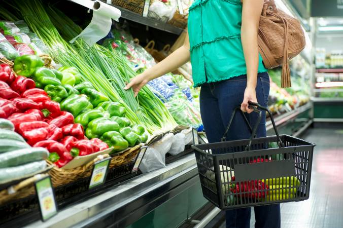 Woman selecting produce at a grocery store.