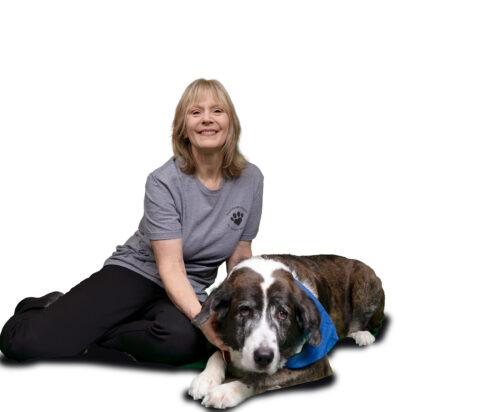 Woman sitting on ground with dog.