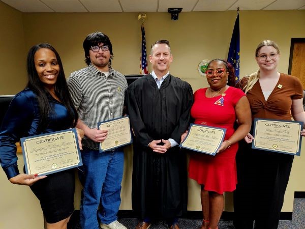 New Franciscan VASIA volunteers hold their certificates after being sworn in earlier this month seen here with Lake Superior Court Probate Commissioner Ben Ballou.