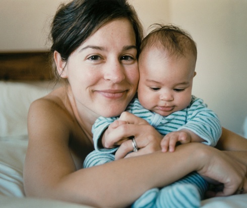 Mom hugging baby on bed