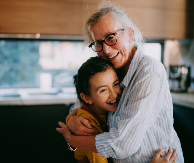 A grandmother hugging her granddaughter