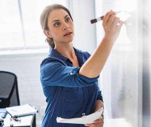 Teacher writing on whiteboard
