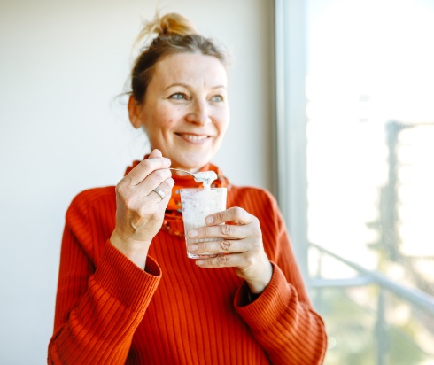 Woman smiling while eating yogurt