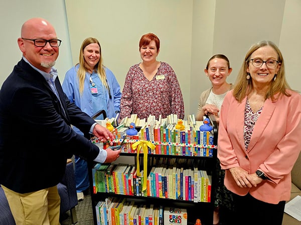 Legacy Foundation Grant Committee member Bob Spajer, left, cuts the ribbon on a new mobile library for the Franciscan Health Crown Point NICU. Joining Spajer are (l-r) NICU Manager Jennifer Creighton, Legacy Foundation Grants Coordinator Kelly Baer, Northwest Indiana Literacy Council Treasurer Dr. Sharon Pratt and Northwest Indiana Literacy Council Secretary Deb Carlson.
