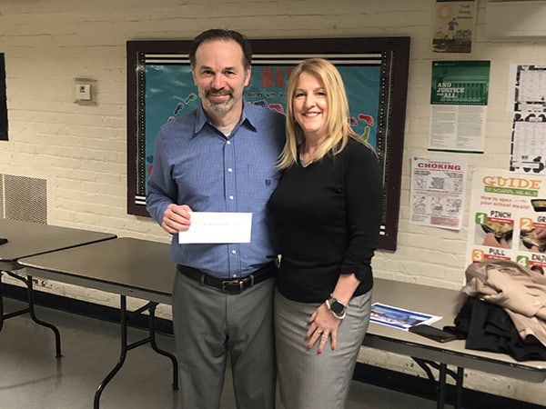 St. Agnes School Principal Matt Lungaro presents Franciscan Health Foundation Executive Director Laurie Crosby with a check after students raised $1,400 for babies and new moms in need served by Franciscan Health Olympia Fields.