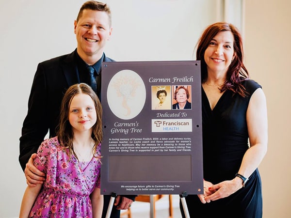 Kristen Himmerick, right, stands with her husband, Shaun, and daughter, Stella, at the dedication of Carmen’s Giving Tree in her mother’s memory at Franciscan Health Olympia Fields earlier this month.