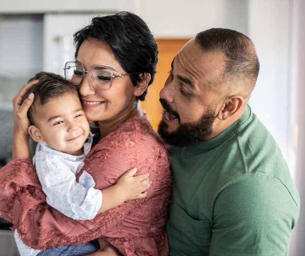 parents hugging toddler boy