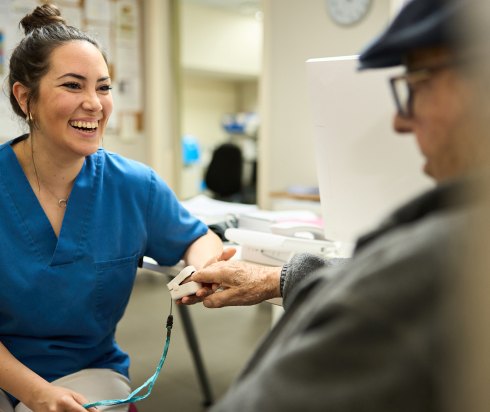 nurse taking pulse of elderly male patient