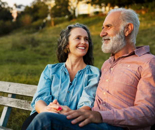 Elderly couple sitting together on a park bench