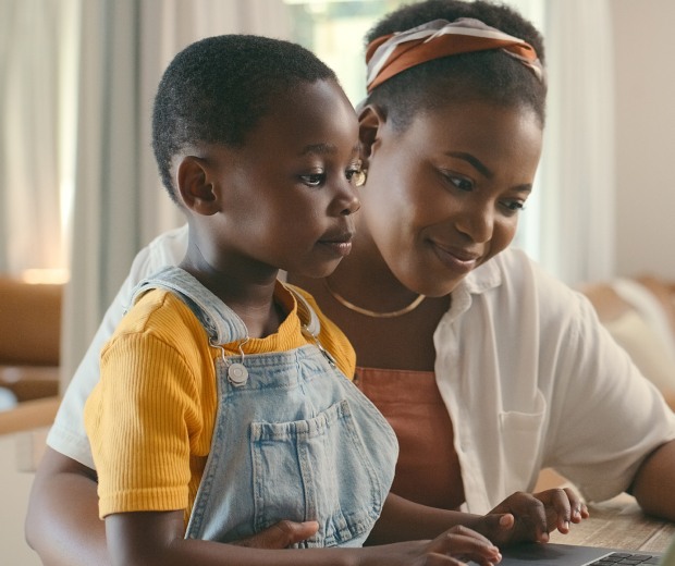 mom and son smile looking at laptop